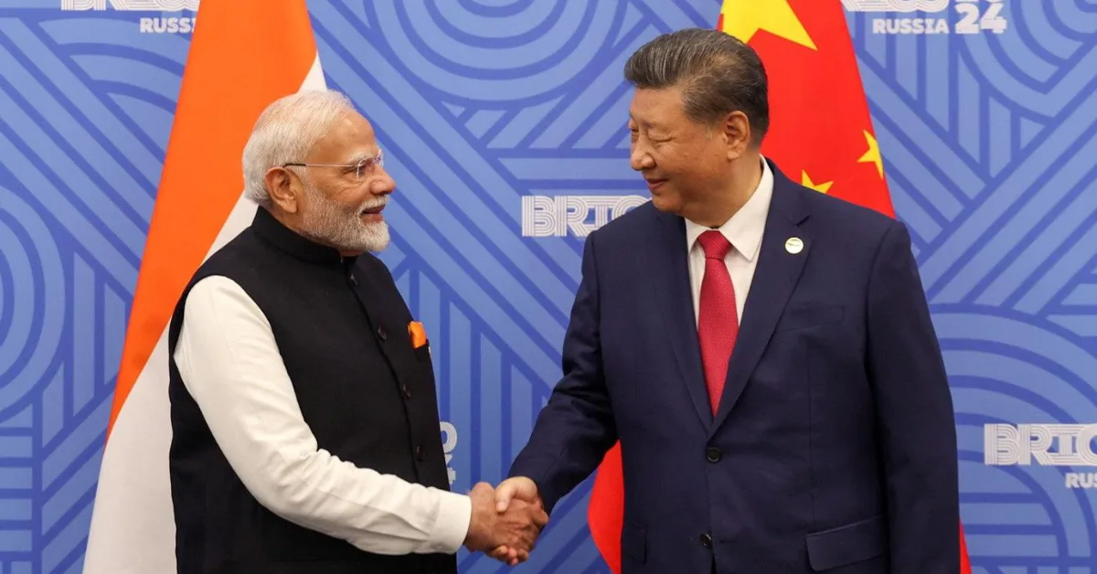 Indian Prime Minister Narendra Modi and Chinese President Xi Jinping shaking hands in front of their respective national flags during a bilateral meeting, highlighting the strategic relationship between India and China.